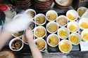 A staff member prepares small bowls of noodle for participants of Tokyo Ramen Tours at Shinbusakiya…