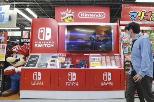 A man walks by Switch from Nintendo at an electronics retail chain store in Tokyo, on October 13, 2…