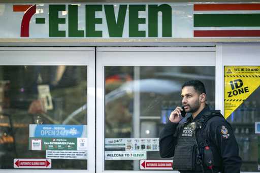 A Vancouver Police officer talks on his phone outside of a crime scene at a 7-Eleven after a stabbi…