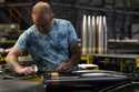 A steel worker inspects a 155 mm M795 artillery projectile at the Scranton Army Ammunition Plant, A…