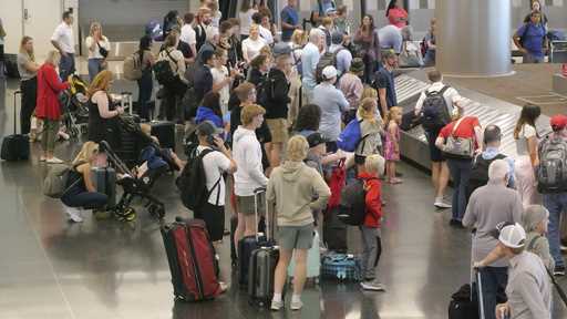 Holiday travelers wait for their luggage after arriving at Salt Lake City International Airport Wed…