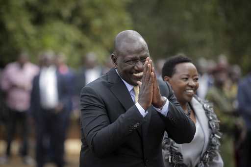 Kenya's President William Ruto gestures to party officials as he walks with his wife Rachel Ruto as…