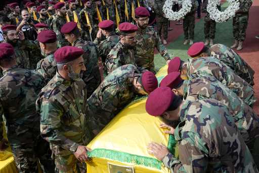 Hezbollah members mourn over the coffins of two of their comrades who were killed on Wednesday when…