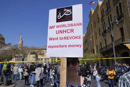 A protesting depositor carries a placard at a protest near Parliament in downtown Beirut, Lebanon, …