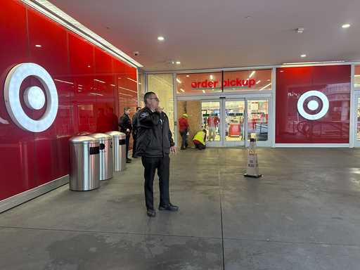 A security guard stands outside a Target store after two security guards were shot and wounded area…