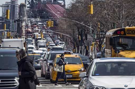 Pedestrians cross Delancey Street as congested traffic from Brooklyn enters Manhattan over the Will…