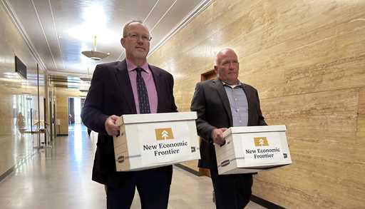 Steve Bakken, left, and Casey Neumann, of the New Economic Frontier ballot initiative group, carry …