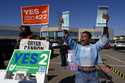 Nikko Griffin, left, and Tyra Patterson, call out to arriving voters for several issues, including …