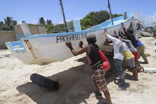People relocate a boat for its protection ahead of the arrival of Hurricane Beryl in Progreso, Mexi…