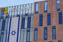 An Israeli flag is draped over the Microsoft offices in a building in the Gav Yam technology park i…