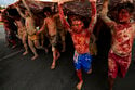 Indigenous people painted with red ink representing spilled Indigenous blood and clay representing …