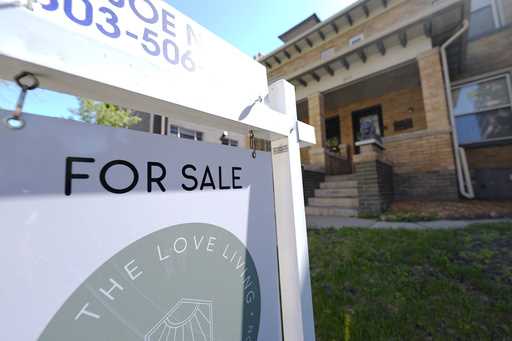 A sale sign stands outside a duplex on the market Friday, May 24, 2024, in downtown Denver