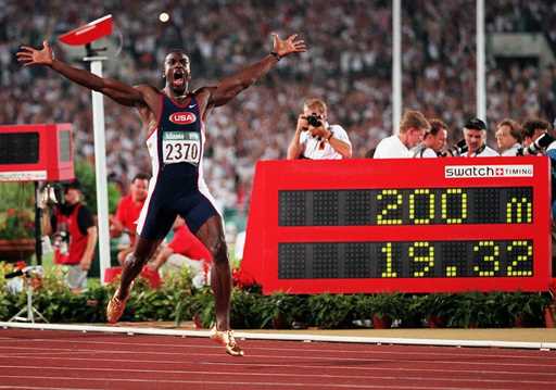 Michael Johnson, of the United States, celebrates after he won the men's 200-meter final in a world…