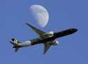 An Air New Zealand passenger plane flies past the moon on its way to the Los Angeles International …