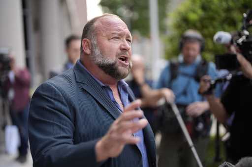 Right-wing conspiracy theorist Alex Jones speaks to the media after arriving at the federal courtho…