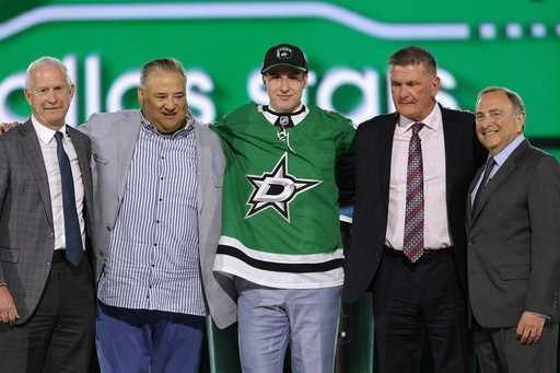 Emil Hemming, center, poses after being selected by the Dallas Stars during the first round of the …