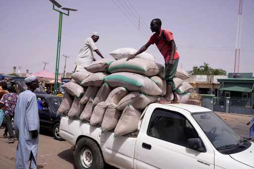 Workers offload bags of grains from a truck at a market in Gombe, Nigeria, on June 3, 2024