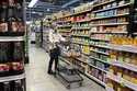 A woman checks prices as she shops at a grocery store in Wheeling, Ill