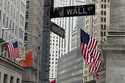 American flags hang from the front the New York Stock Exchange, right, on April 11, 2024, in New Yo…