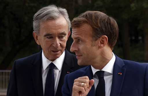 LVMH luxury group CEO Bernard Arnault, left, and French President Emmanuel Macron arrive at Fondati…