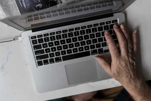 A person works on a laptop computer in Hudson, Wis