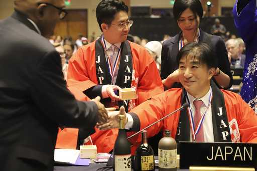 Japan's Takehiro Kano, ambassador to UNESCO, reacts after the traditional Japanese brewing of sake …