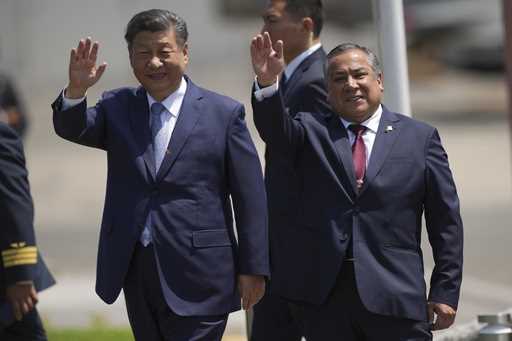 Chinese President Xi Jinping, left, and Peru's Prime Minister Gustavo Adrianzen, wave on the airpor…