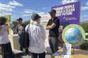 People look at exhibits at the Climate Science Fair, an outdoor exhibit hosted by the Emerson Colle…