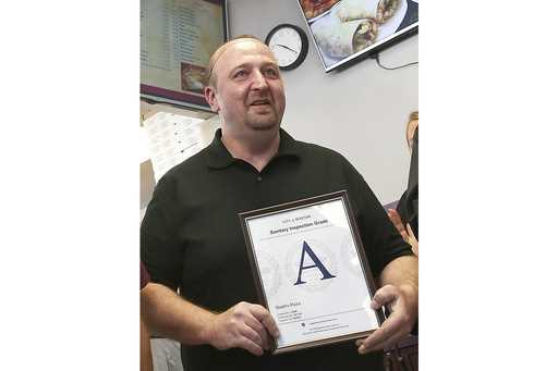 Stavros Papantoniadis, owner of Stash's Pizza, a Boston sanitary grade certificate after inspection…