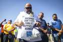 Longshoremen bow for a prayer during a strike at the Bayport Container Terminal on Tuesday, October…