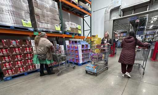 Shoppers guide their carts through the milk display in a Costco warehouse Thursday, January 23, 202…