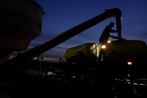 Mark Woodruff loads soybean seeds into a planter on April 22, 2024, in Sabina, Ohio