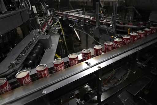 Coca-Cola cans move down a conveyer belt in the Swire Coca-Cola bottling plant October 20, 2023, in…