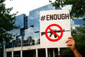 A protester holds a sign outside the National Rifle Association's headquarters building during a vi…