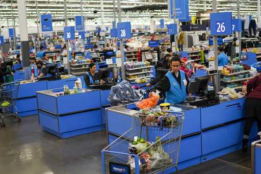 Cashiers process purchases at a Walmart Supercenter in North Bergen, N