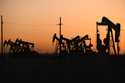 An array of pumpjacks operate near the site of a new oil and gas well being drilled April 8, 2022 i…