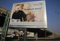 A man walks under a billboard displaying an advertisement for Saudi Arabia's state-owned oil giant …