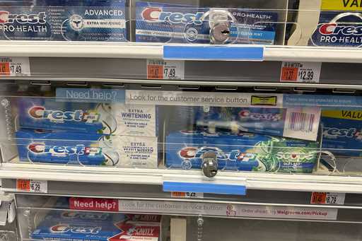 Tubes of toothpaste are displayed behind a locked, plastic barrier to prevent shoplifters from stea…