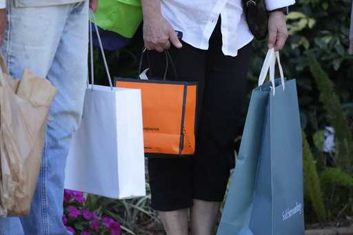 Shoppers carry bags after making purchases in Bradenton, Fla