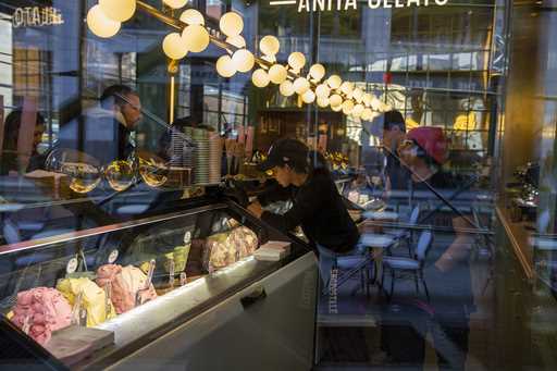 People working at a gelato shop serve customers in New York on February 18, 2024