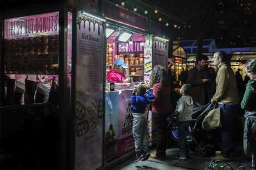 People wait in line for hot donuts at Bryant Park's Winter Village, Tuesday, November 26, 2024, New…