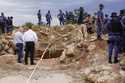 Police officers and private security personnel stand by the opening of a reformed gold mineshaft wh…