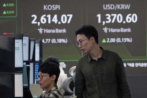 Currency traders watch monitors near a screen showing the Korea Composite Stock Price Index…