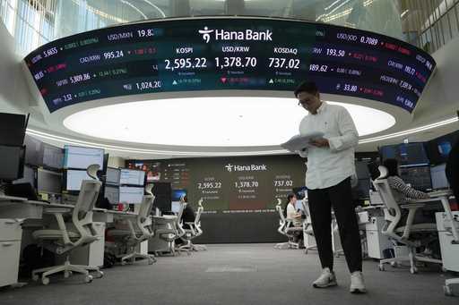 A currency trader reads documents at the foreign exchange dealing room of the KEB Hana Bank headqua…