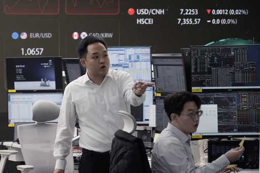 Currency traders work at the foreign exchange dealing room of the KEB Hana Bank headquarters in Seo…