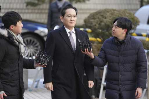 Samsung Electronics Chairman Lee Jae-yong, center, is questioned by reporters upon his arrival at t…