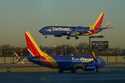 A Southwest Airlines plane prepares to land at Midway International Airport while another taxis on …