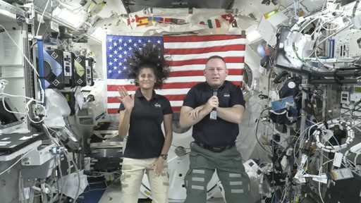 In this image from video provided by NASA, astronauts Suni Williams, left, and Butch Wilmore give a…