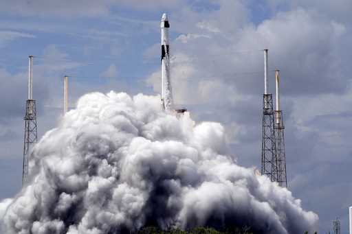 A SpaceX Falcon 9 rocket, with a crew of two astronauts, lifts off from launch pad 40 at the Cape C…