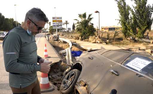 Jorge Tarazona stands next to a car in Paiporta, Valencia, Spain, Wednesday, November 5, 2024, wher…